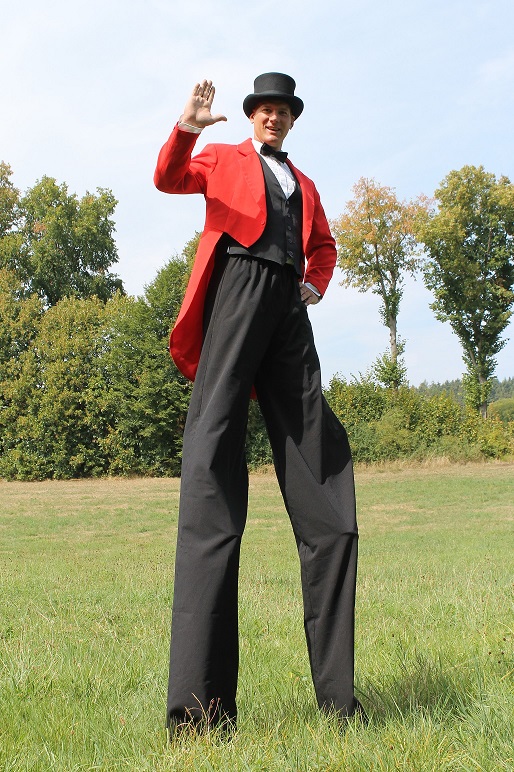 Larifari im roten Frack auf Stelzen